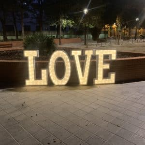 Decoração de casamento com a palavra "LOVE" gigante iluminada em esferovite, disponível para aluguer ou compra em Portugal.