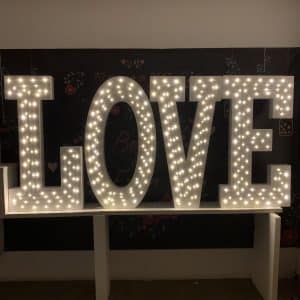 Palavra "LOVE" gigante em esferovite (poliespán) com iluminação, ideal para decoração central de casamentos.