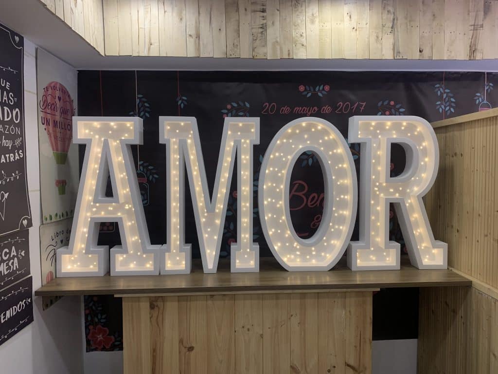Decoração de casamento com a palavra "AMOR" gigante iluminada em esferovite, disponível para aluguer ou compra em Portugal.