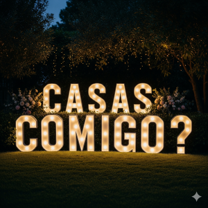 Letras gigantes e iluminadas "CASAS COMIGO?" em um jardim à noite, ideal para um pedido de casamento romântico.