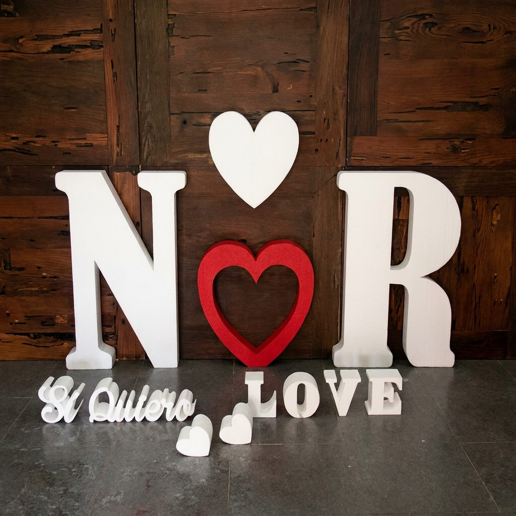 Letras gigantes brancas xxl com as iniciais N e R e dois corações, um branco e um vermelho, como decoração de photocall para casamentos.