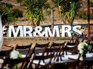 Letras gigantes de esferovite com a hashtag MR e MRS para decoração de casamento ao ar livre.
